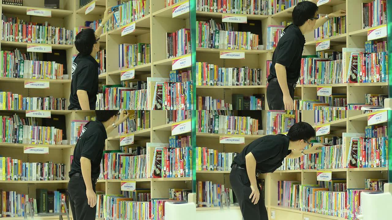 英俊的亚洲男学生在图书馆挑书