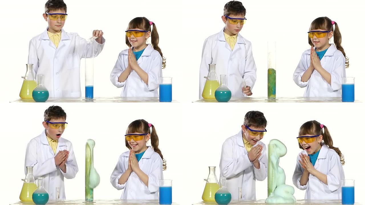 两个可爱的化学家孩子用白色背景上孤立的蓝色泡沫做有趣而成功的实验，慢动作