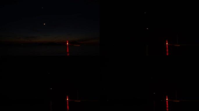 天空和新月的时间流逝。海滨小镇Turgutreis和壮观的月景。金星和灯塔