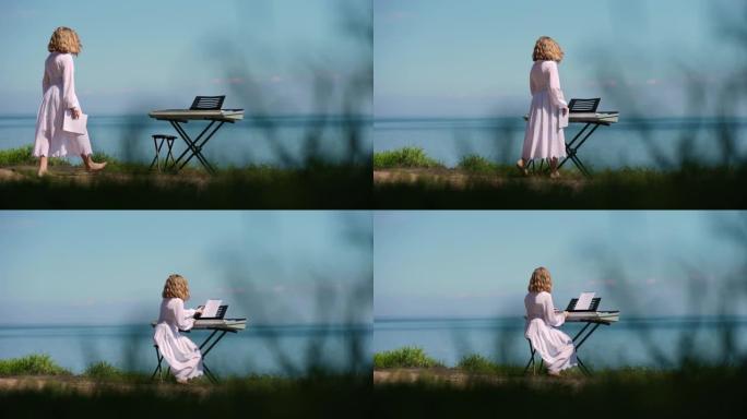 河岸上的钢琴合成器，十几岁的高加索女孩进入慢动作走向乐器。自信的有创造力的音乐家坐在风景的背景下。