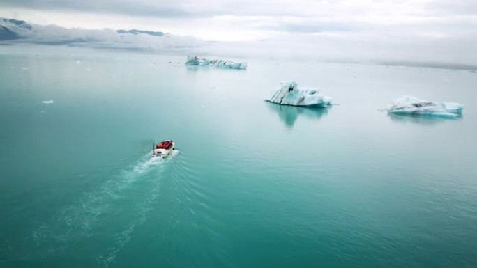 在Jokulsarlon的冰山中航行的两栖船的空中无人机镜头