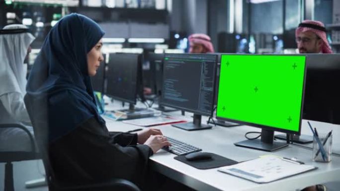 阿拉伯女性软件开发人员在具有绿屏模拟显示的台式计算机上工作。年轻的中东专家测试创新大数据区块链项目的