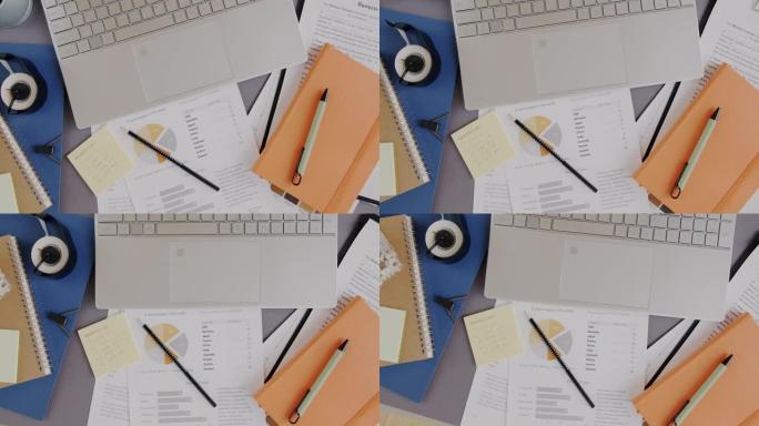 桌面带有笔记本电脑和商务文档的办公桌的俯视图特写