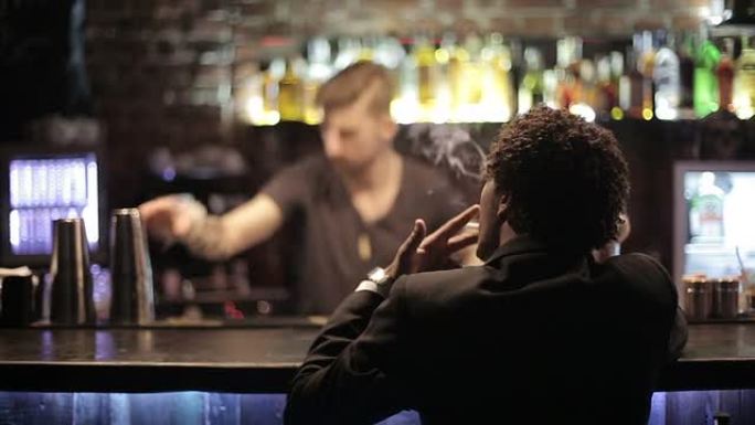 黑人坐在酒吧里抽烟