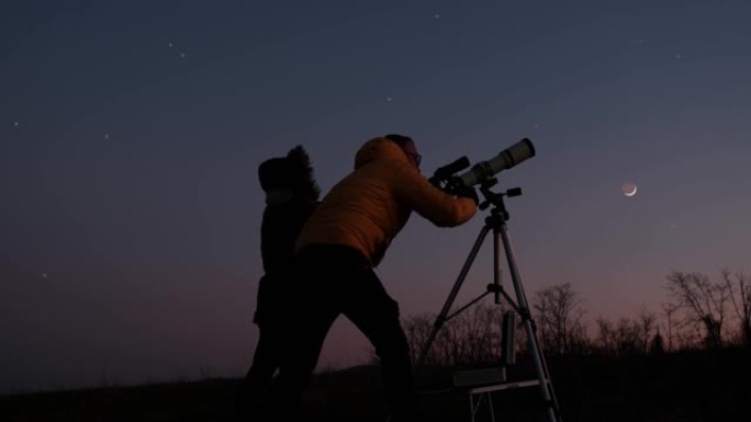 女人和男人用天文望远镜看着夜空，星星，行星，月亮和流星。