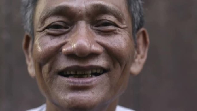 成熟的亚洲男人微笑着看着相机的特写镜头
