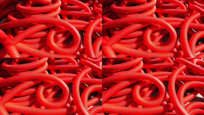 工业背景。塑料波纹管，卷内排水，特写。红色管道或管道。慢动作。
