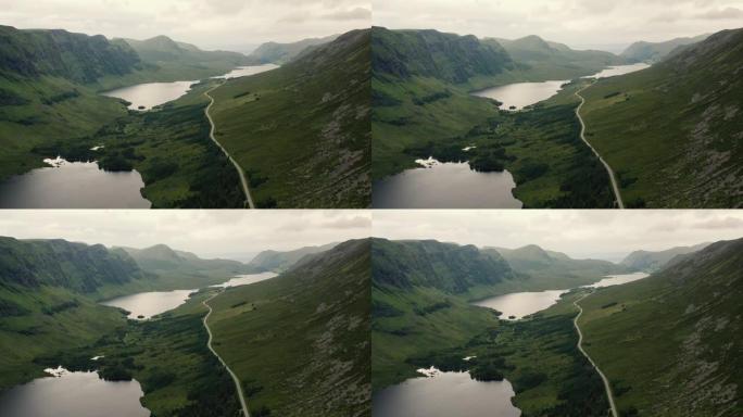 挪威绿色山丘上风景秀丽的湖泊之路的航拍画面