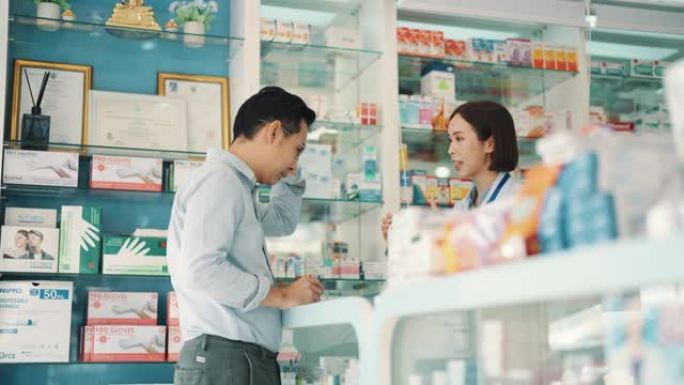 亚洲成熟男子在药店买药。客户从药房的药剂师那里获得帮助。小企业。药。健康的概念。