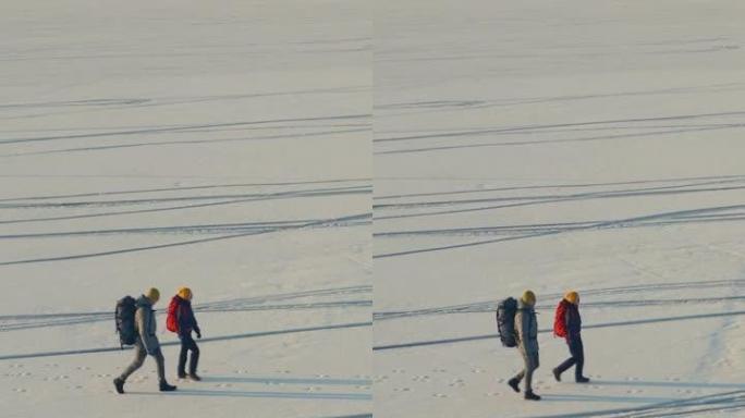 两个旅行者在空旷的雪场中漫步