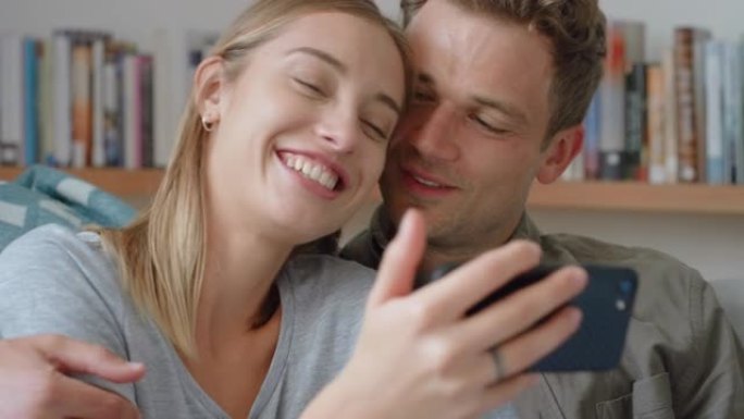 幸福的情侣一起用智能手机在家里沙发上放松美丽的女人在社交媒体上分享关系4k