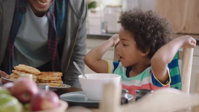 快乐的小男孩早餐吃新鲜华夫饼，父亲在家厨房享受美味的自制美食