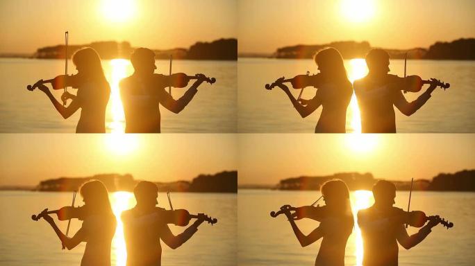 小提琴二重唱男女在日落时演奏小提琴