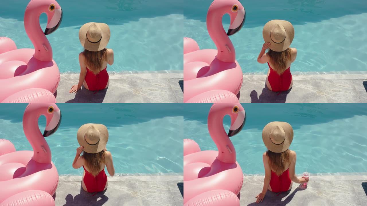比基尼女人坐在游泳池边喝酒享受夏日晒太阳放松粉色火烈鸟游泳管充气4k