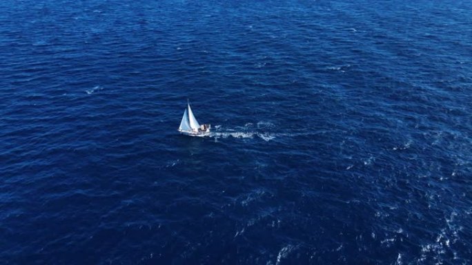 旅行自由。在海中航行的白色美丽游艇的无人机视图