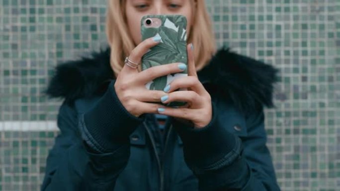 年轻女子使用智能手机发短信在城市在线等待社交媒体消息