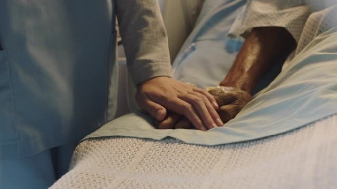 护士在病床上触摸老人的手，对康复的老年患者表示喜爱