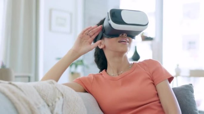 虚拟现实的快乐女人在沙发上的护目镜，未来的视频游戏和网络朋克3d体验在家里。虚拟现实、数字高科技和具