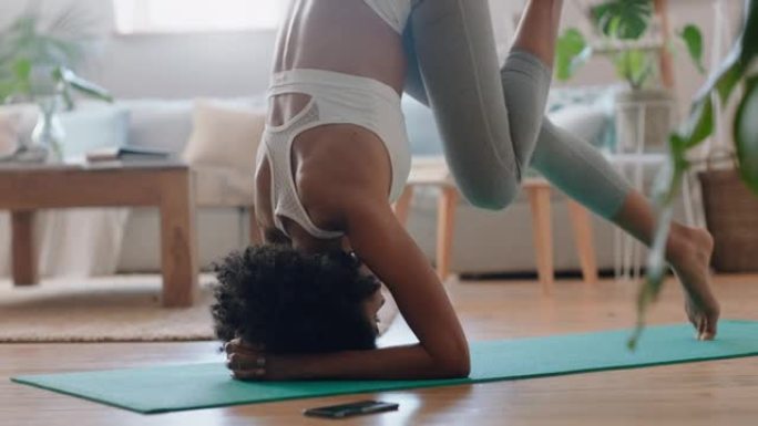 健康混血女子在家练习瑜伽，在客厅练习支撑倒立姿势，享受早晨健身锻炼4k镜头