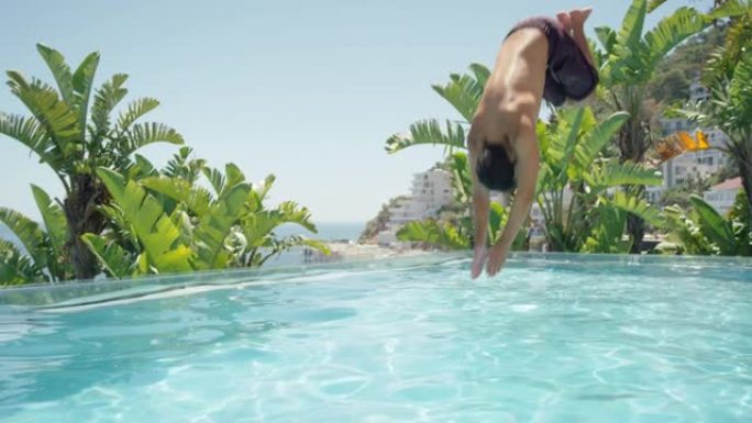 年轻人在快乐的暑假里跳进游泳池享受温暖阳光明媚的日子在豪华酒店度假村游泳地中海旅游4k