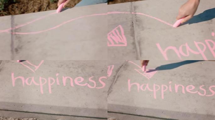 女人用粉红色粉笔在地面上书写幸福的少女享受创造力