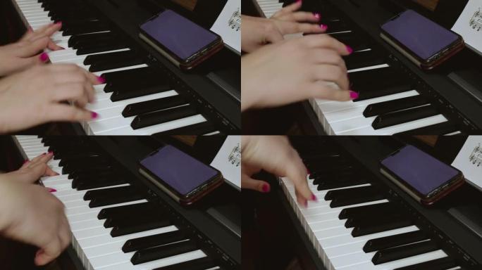 一名妇女根据手机和纸上记录的音符弹奏电子钢琴。钢琴和女性手的特写镜头