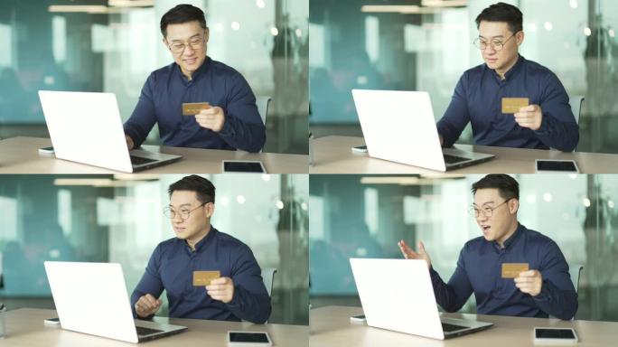 微笑的亚洲IT程序员员工在办公室工作场所用笔记本电脑用信用卡付款快乐的客户商人在线购物付款