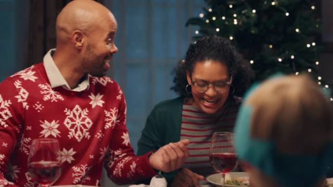 快乐的非洲裔美国夫妇和朋友一起享受圣诞晚餐，庆祝节日聊天，在家分享晚餐4k