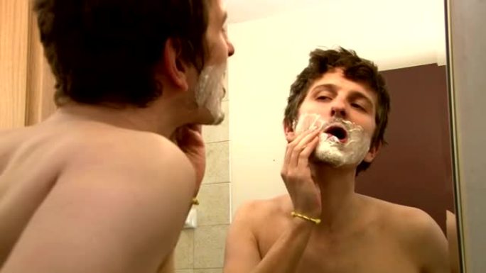 男子在镜子前涂剃须膏