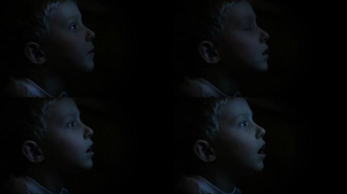 小男孩在黑暗中看电视
