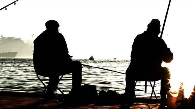 码头捕鱼的渔民。剪影拍摄。太阳耀斑。