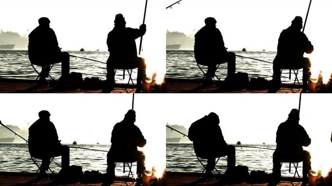 码头捕鱼的渔民。剪影拍摄。太阳耀斑。