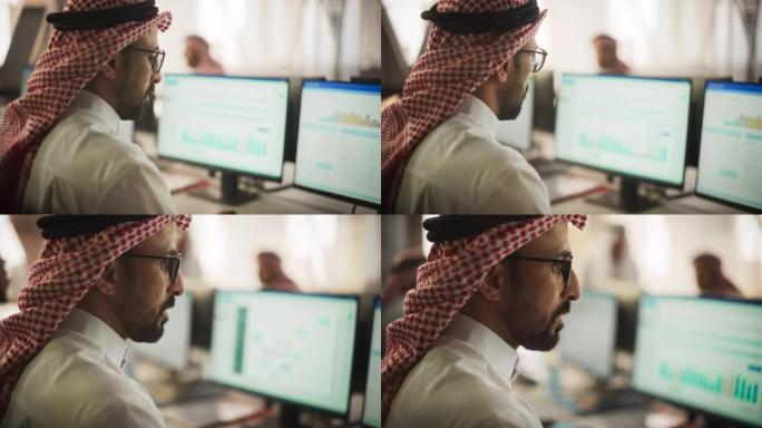 中东金融证券交易员在现代办公室的台式计算机上工作的肖像。阿拉伯簿记员会计企业的财务