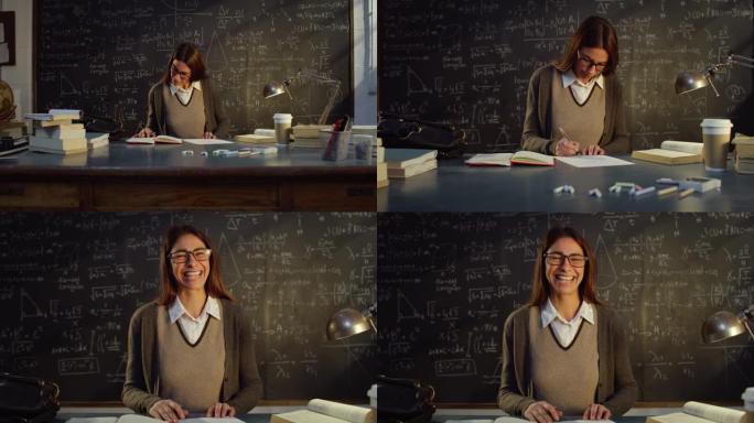 大学教室里年轻女教师的肖像，用数学公式在黑板前的桌子上工作。在大学图书馆学习的理科生看着相机微笑