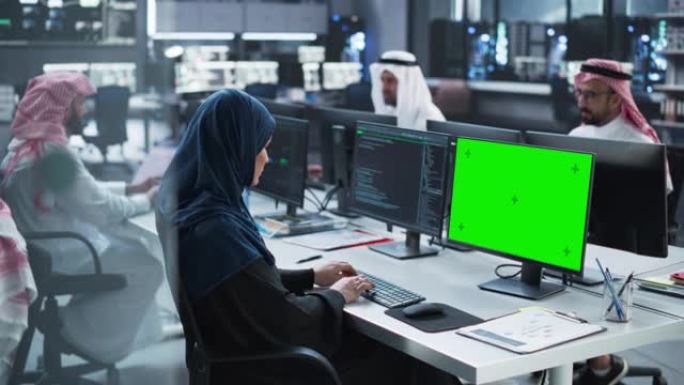 在研究中心工作的中东多元文化男女小组，合作开展了一个在线项目。阿拉伯女性穿着传统服装，使用带有绿屏模