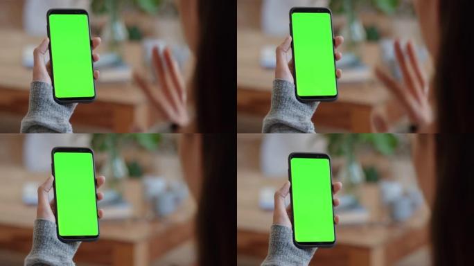 使用智能手机绿屏进行视频聊天的女人在色度键上向朋友挥手，享受垂直方向的手机通信显示4k