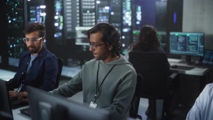 年轻的南亚专家团队在计算机上工作，并在工作场所进行对话。两名男性软件开发人员讨论了他们的人工智能项目