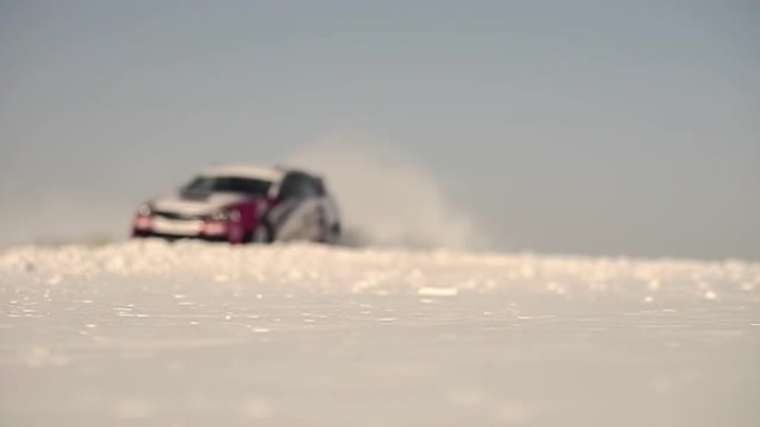 赛车在深雪中快速行驶。一片片雪落在前景上。