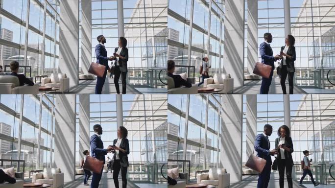 商人聊天非裔美国商人使用智能手机与女同事交谈讨论工作在公司办公室4k
