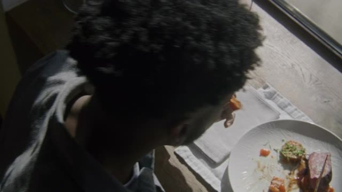 非裔美国人男子割肉吃蔬菜
