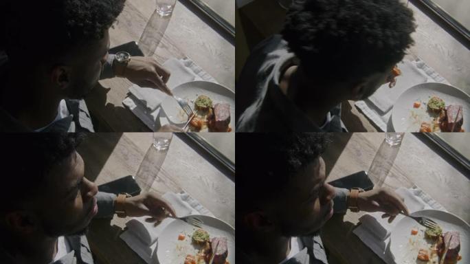 非裔美国人男子割肉吃蔬菜