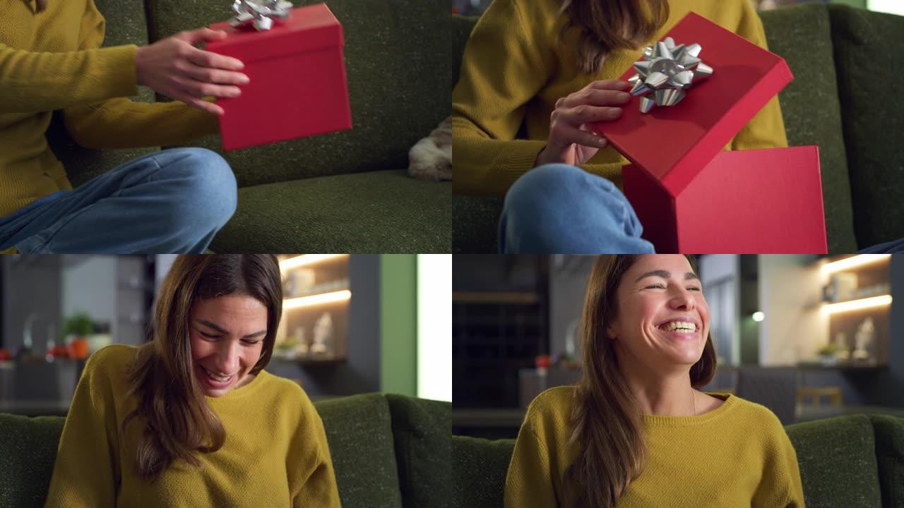 年轻幸福的女人打开红色礼品盒的特写肖像，对她生日时收到的礼物感到兴奋和惊讶。女性早上在家打开圣诞礼物