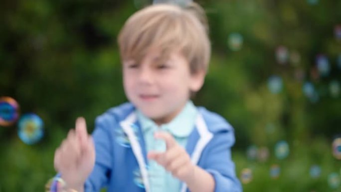 快乐的小男孩顽皮地捕捉肥皂泡漂浮在可爱的孩子在阳光明媚的公园无忧无虑的童年游戏4k