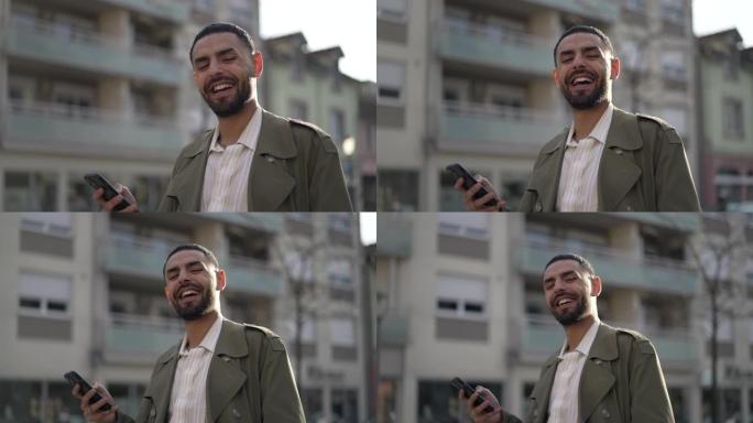 快乐的年轻人笑着特写脸站在城市街道上。中东种族的一名阿拉伯人笑了笑