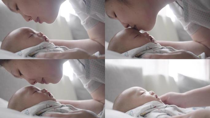 近距离拍摄母亲在睡觉时亲吻儿子