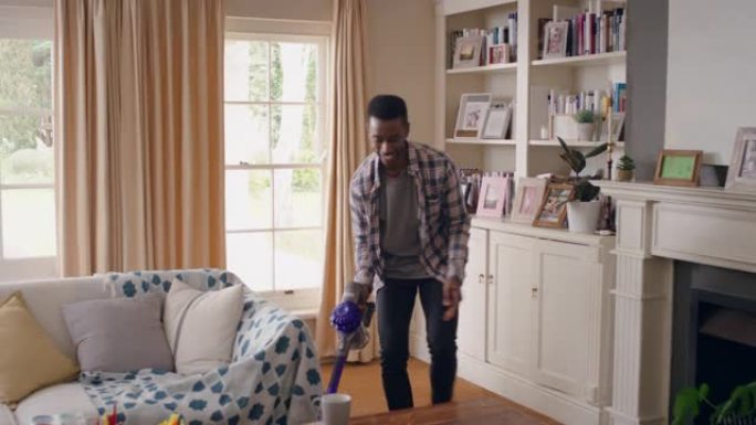 有趣的非裔美国人在家里用吸尘器跳舞庆祝成功，跳舞打扫客厅，周末做家务4k