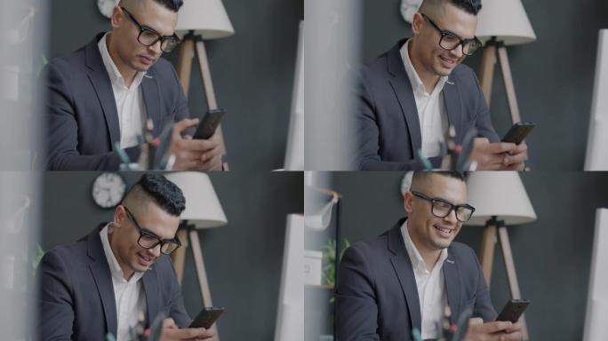 使用智能手机在工作场所进行交流和微笑的中东上班族肖像