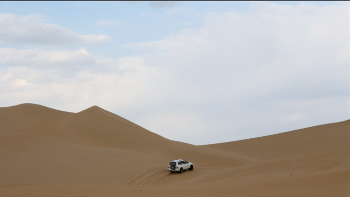 航拍行驶在沙漠的汽车越野车