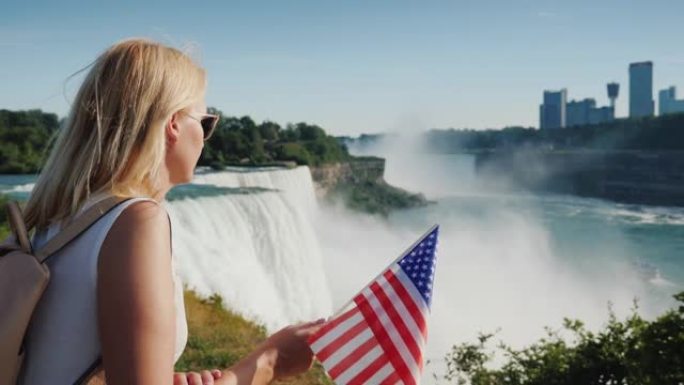 举着美国国旗的妇女从美国海岸欣赏尼亚加拉大瀑布