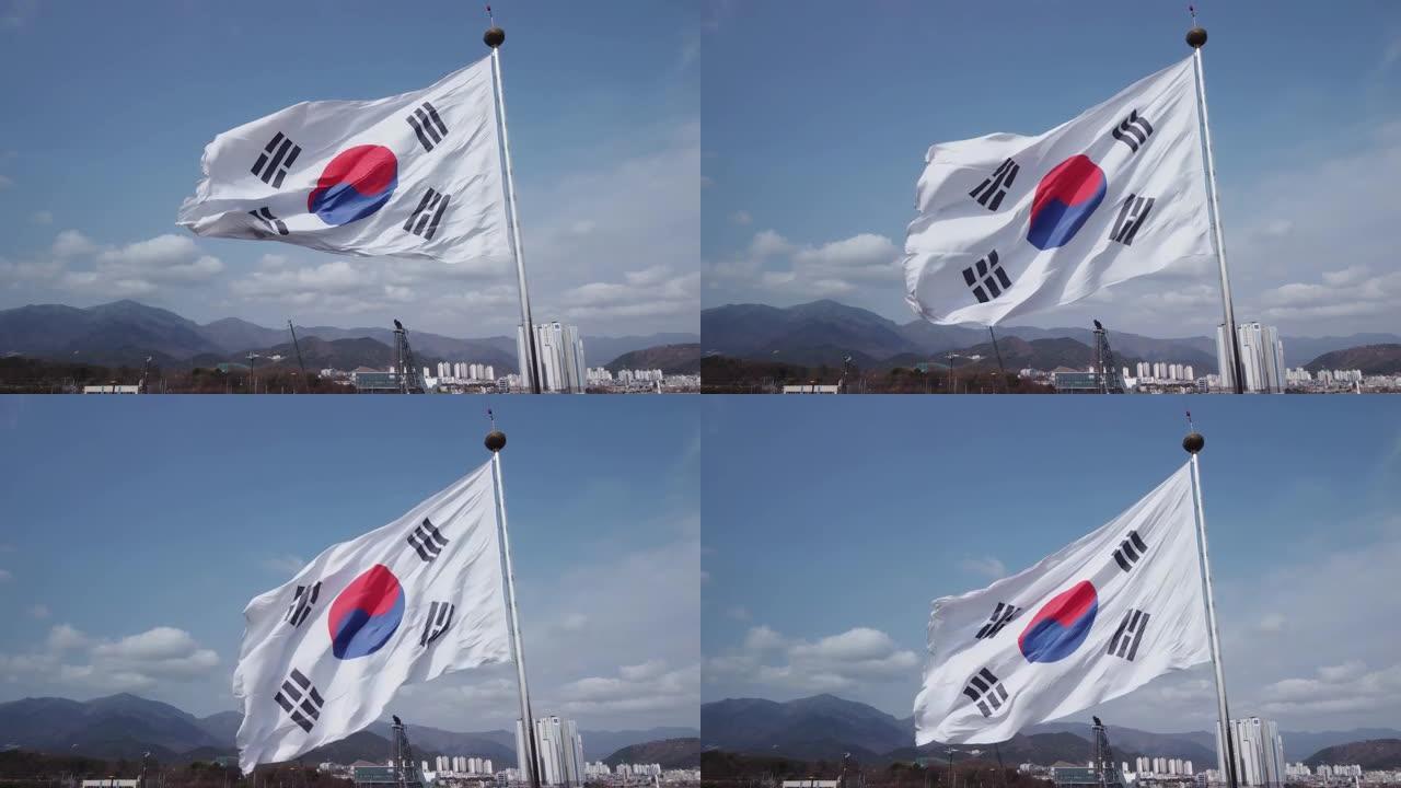 在韩国蔚山车站附近，以60帧/秒的速度鸟瞰一面巨大的太极旗在风中飘扬。